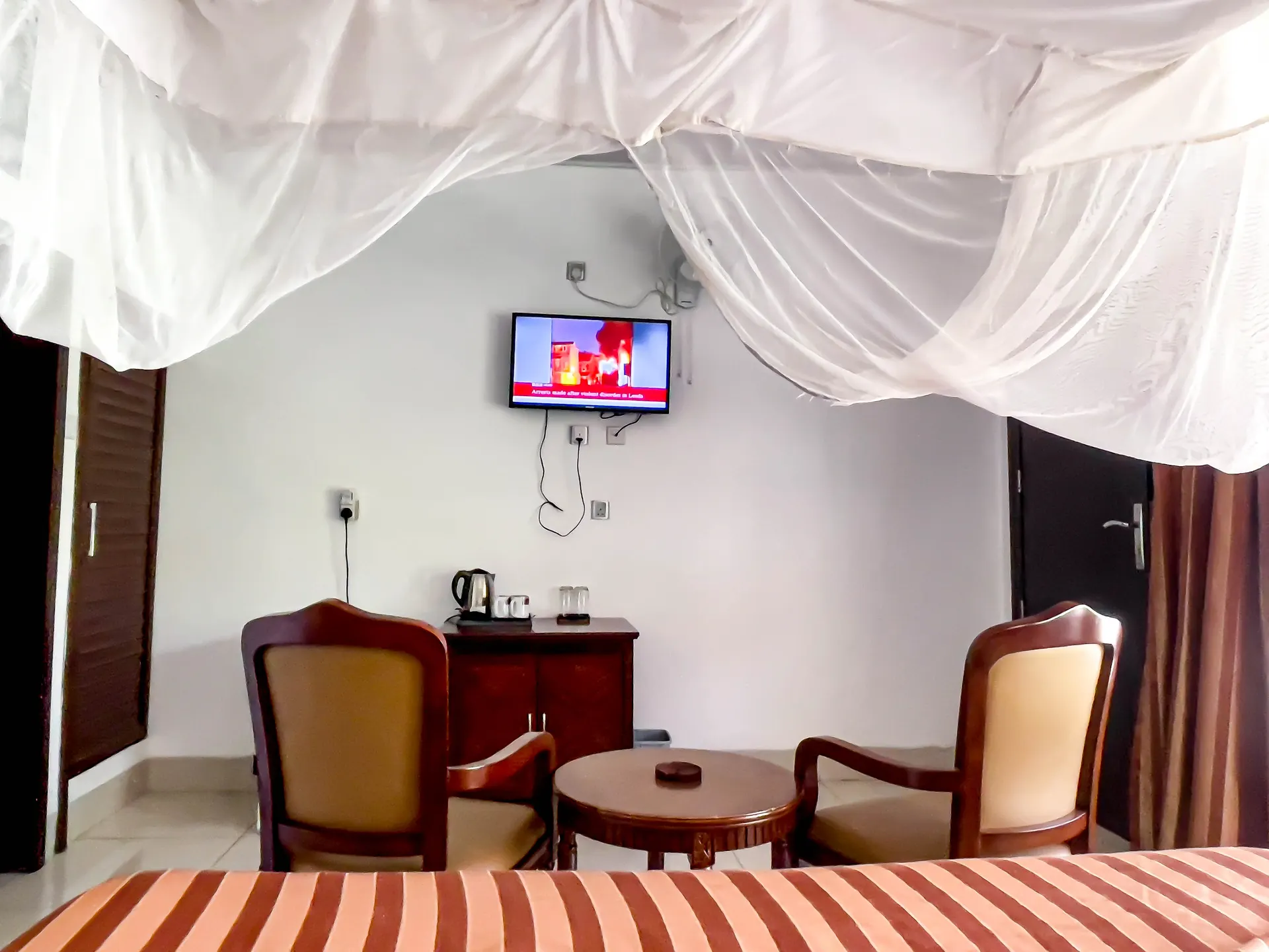 close up front view of room with 2 sofas outside and room number on door